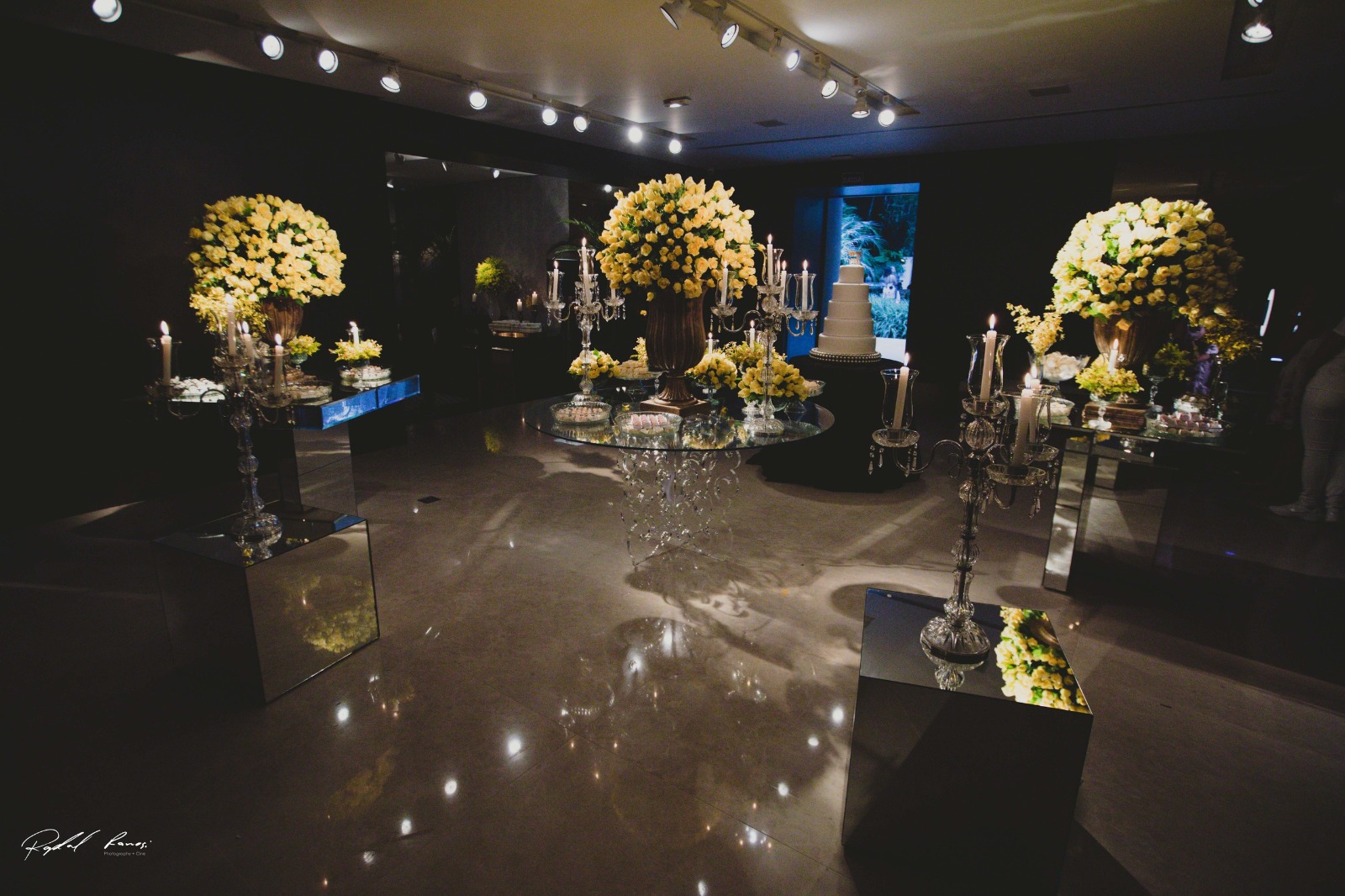 Mesa de bolo com candelabros e flores amarelas