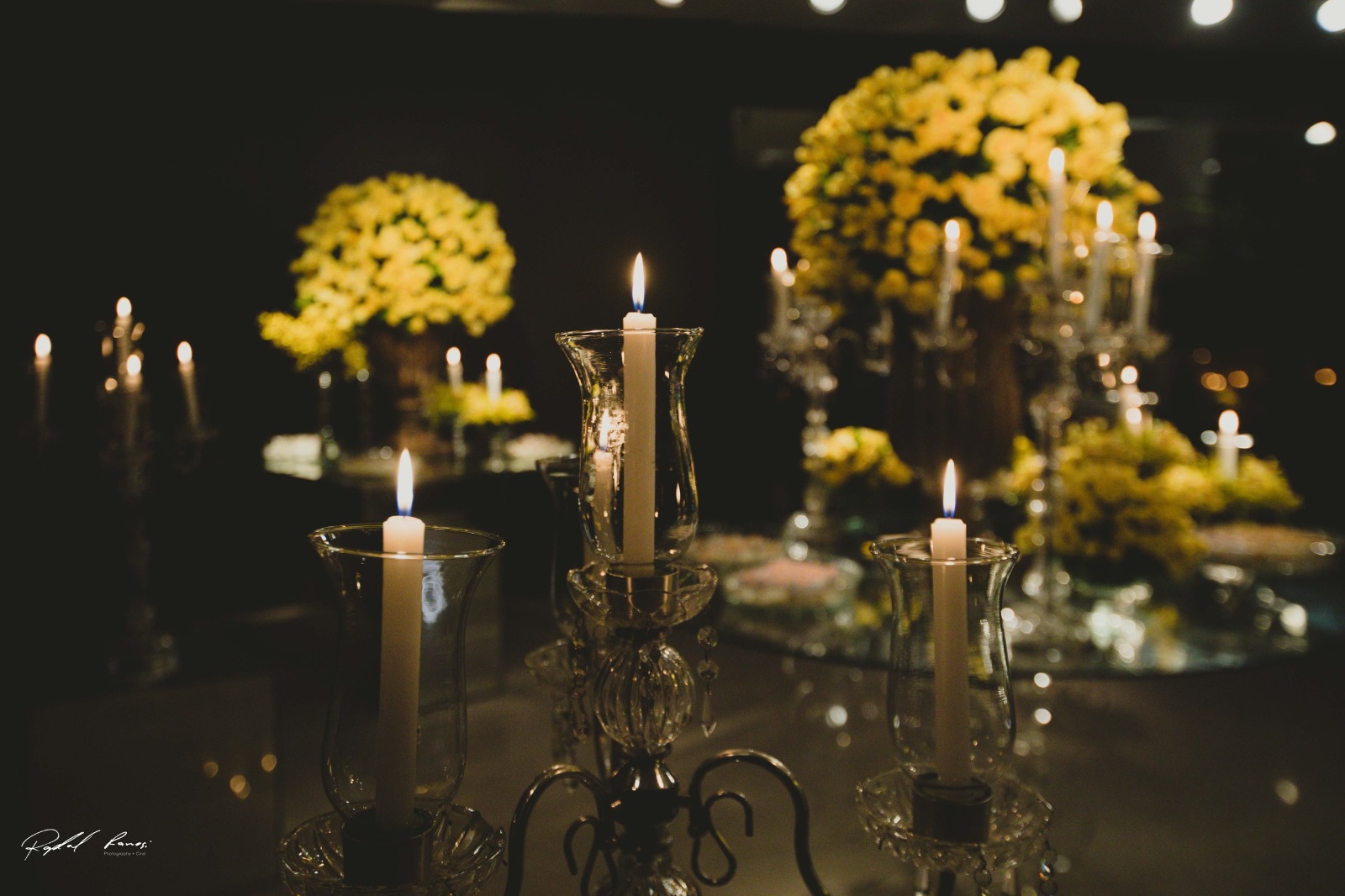 Detalhe de velas e arranjos amarelos em casamento