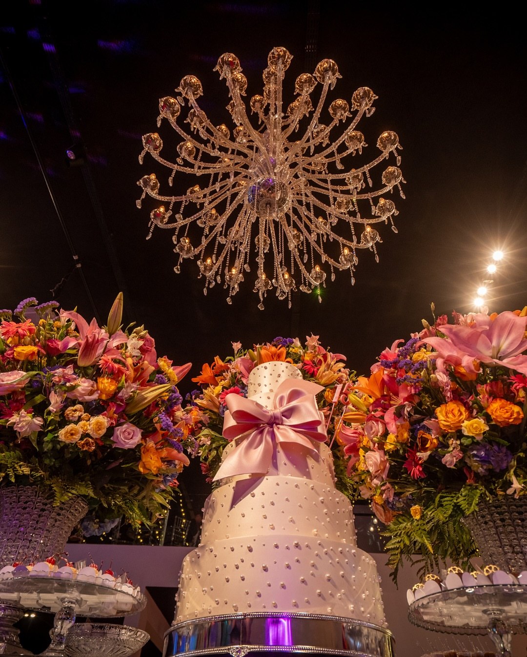 Casamento decorado com bolo de laço rosa e flores coloridas