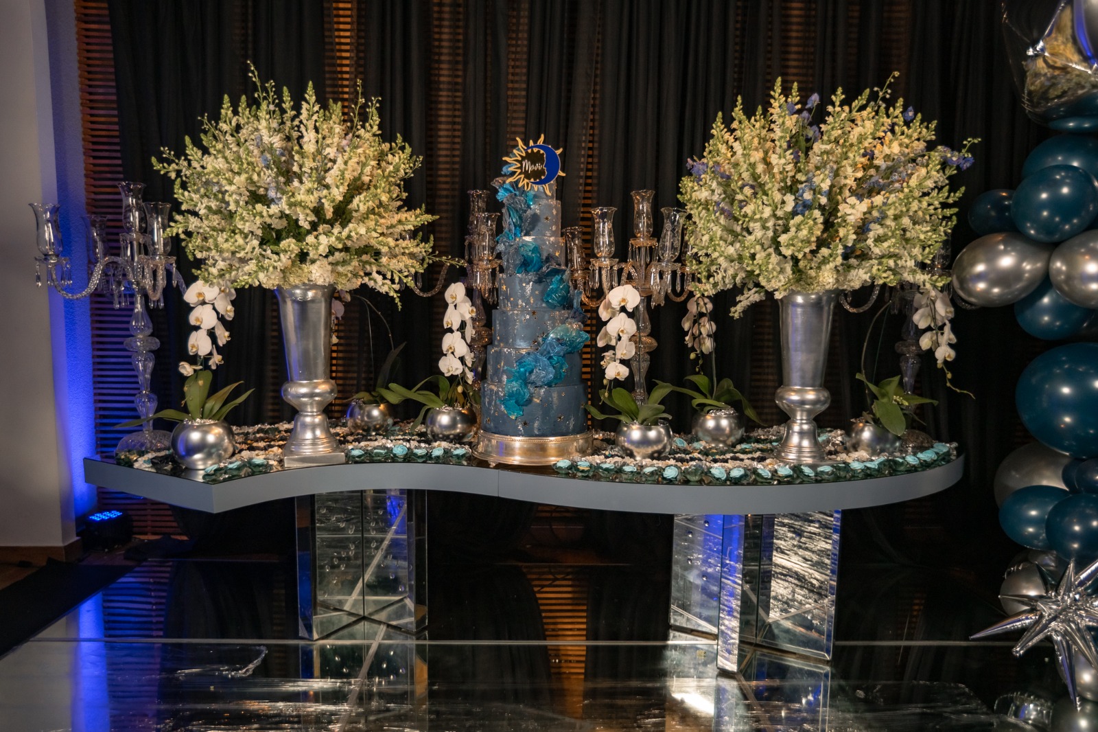 Mesa do bolo de debutante azul com candelabros prateados